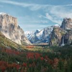 mountain surrounded by trees under cloudy sky