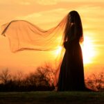 a woman in a long dress with a veil over her head
