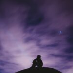 person sitting on black surface looking to sky