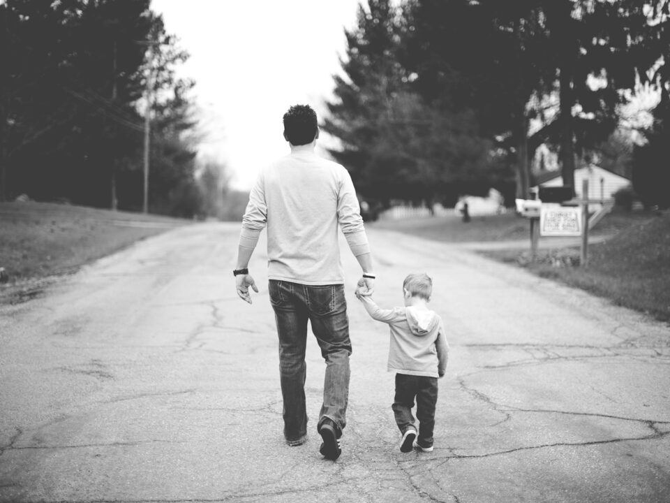 man holding baby's hand