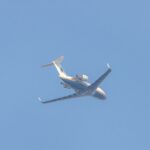 a large jetliner flying through a blue sky