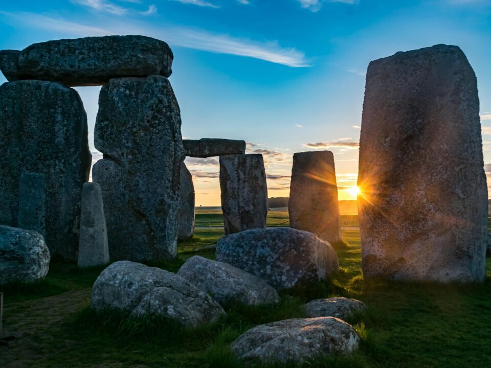 the sun is setting behind the stonehenge monument