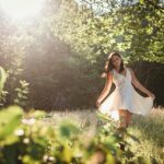 woman in white dress standing on green grass field during daytime
