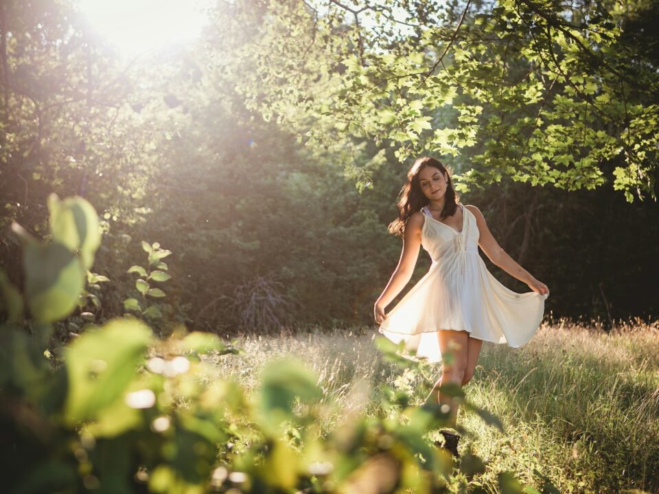 woman in white dress standing on green grass field during daytime