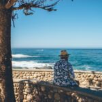 man sitting facing sea