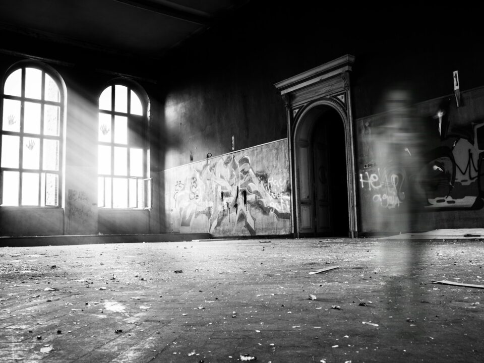 grayscale photo of person standing inside building