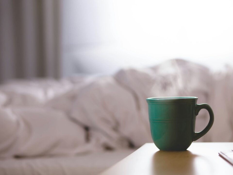 green ceramic mug on wooden desk