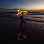 person doing fire dancing on seashore