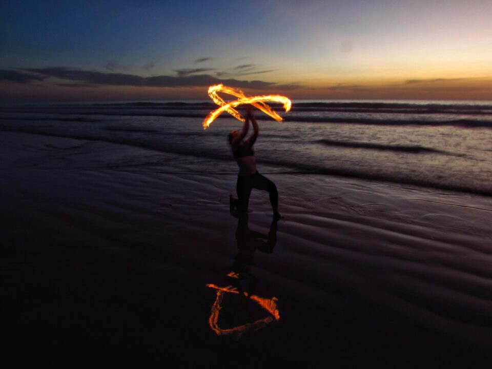 person doing fire dancing on seashore