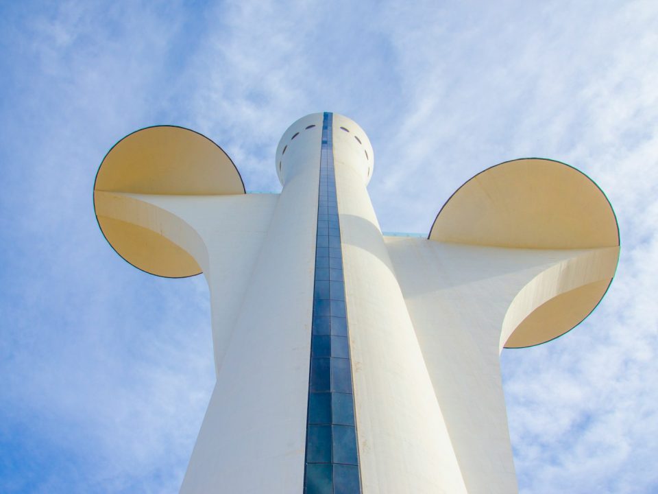 a tall white building with a mickey mouse head on it's side