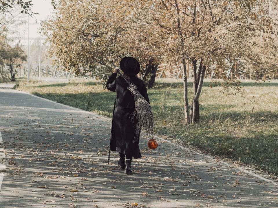 a woman in a black dress is walking down the street