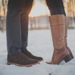 two person in brown boots and shoes on snowy forest
