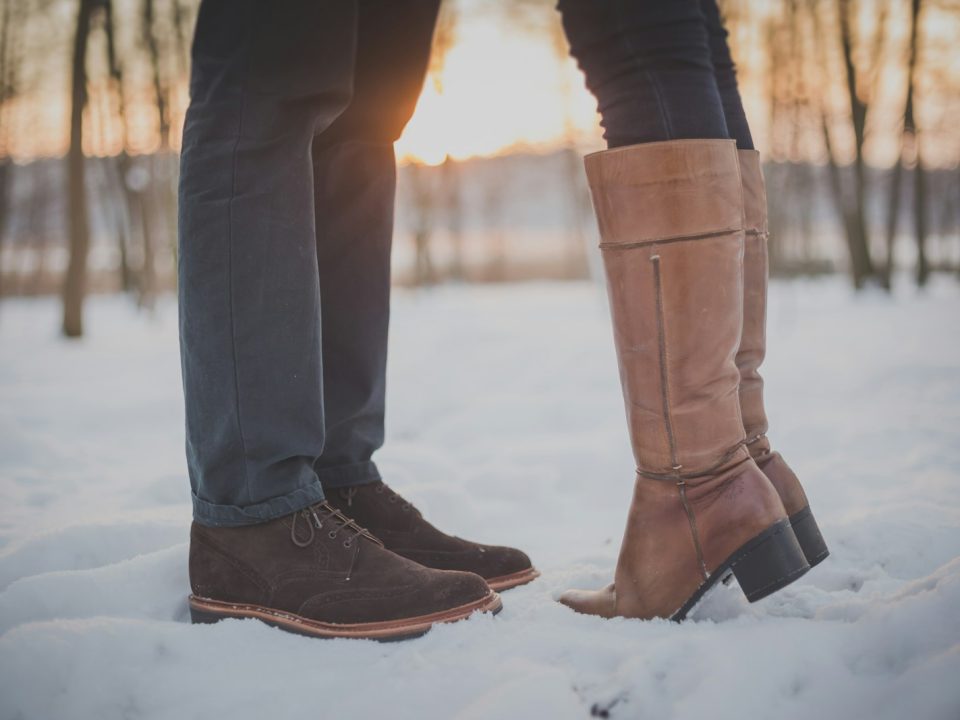 two person in brown boots and shoes on snowy forest