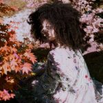 woman sitting near outdoor plants during daytime