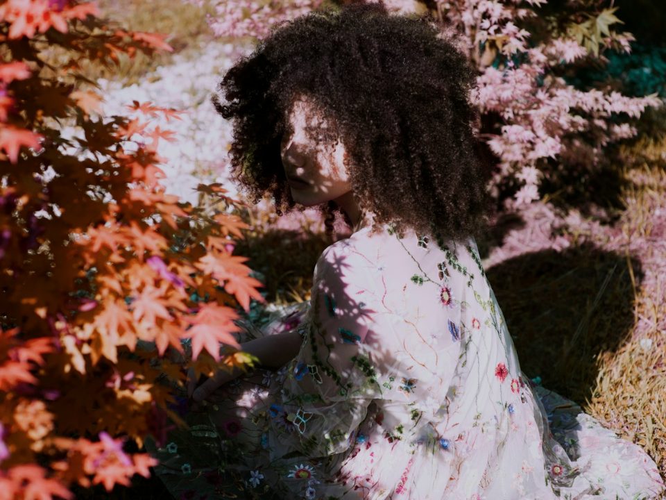 woman sitting near outdoor plants during daytime