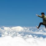 a man jumping off a cliff into the sky