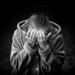 grayscale photography of person covering face