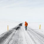 man walking on snowy road
