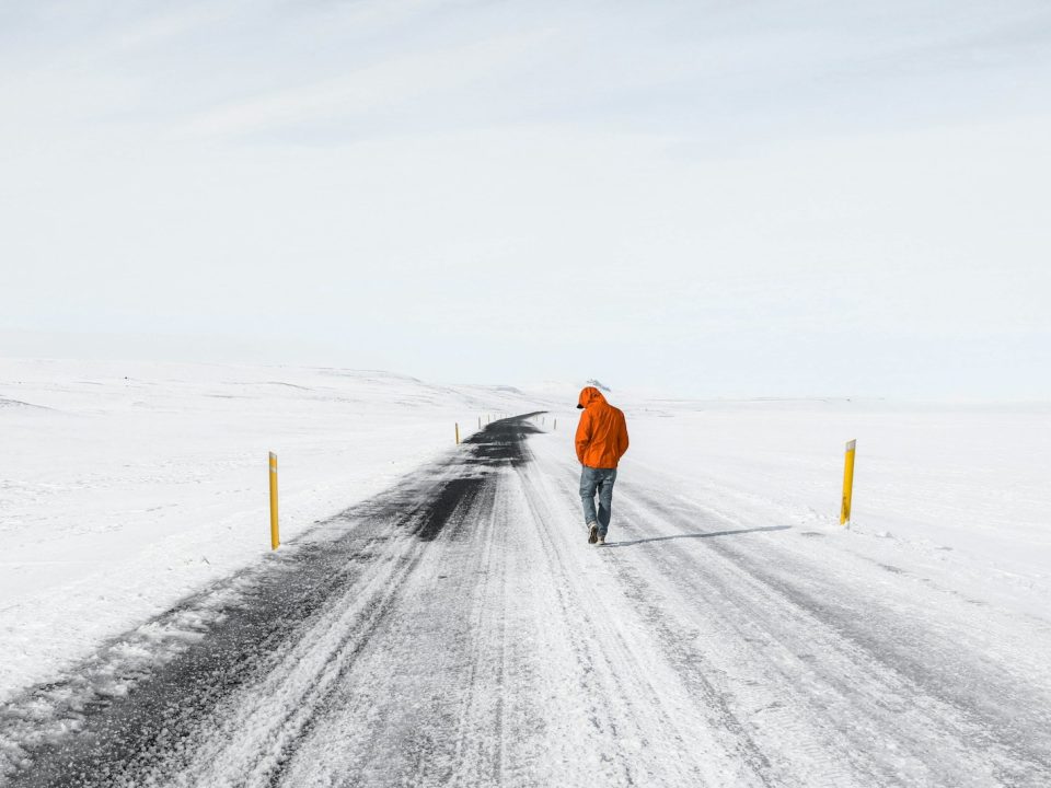 man walking on snowy road