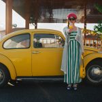a woman standing next to a yellow car